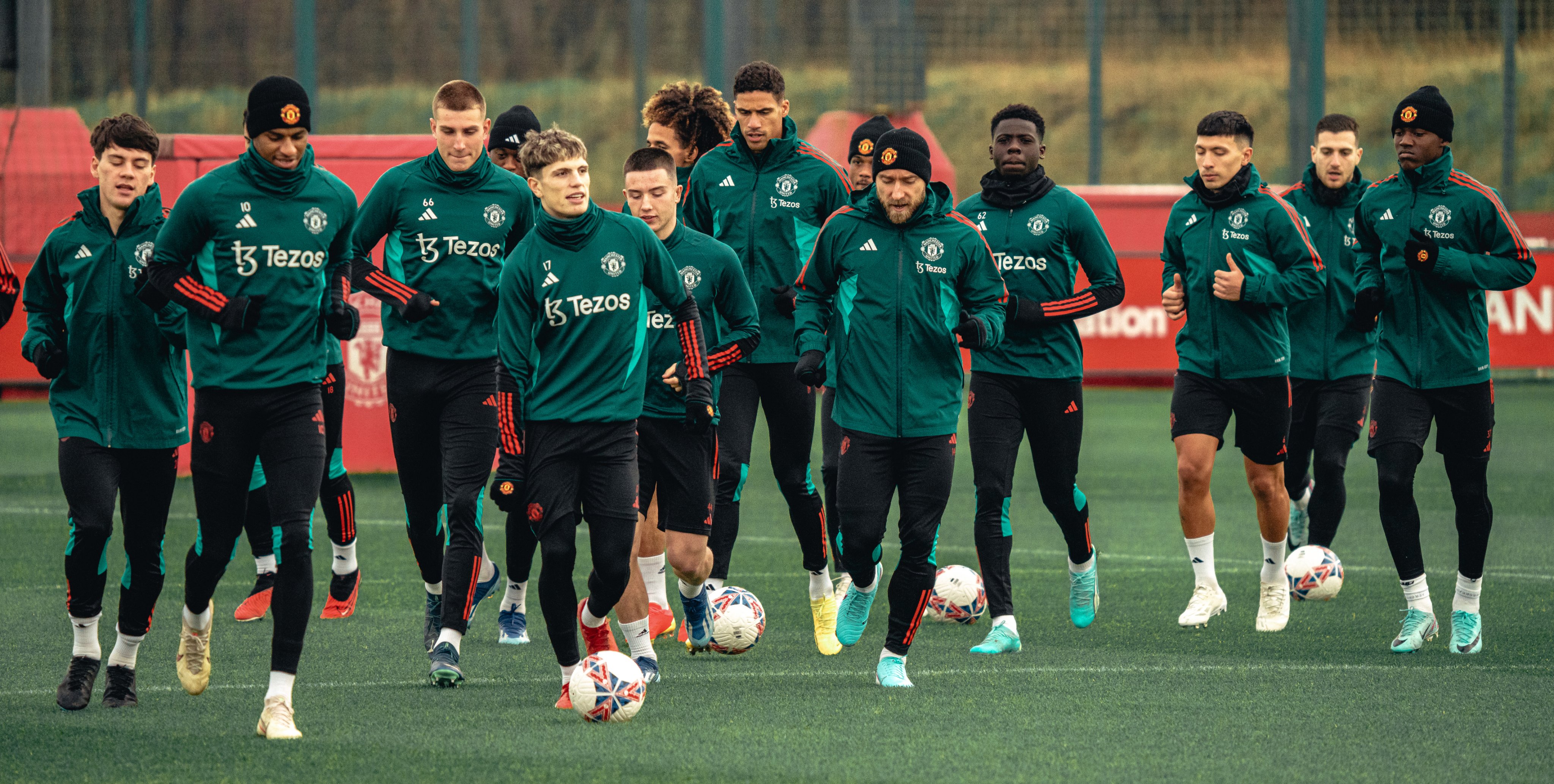 The United squad jog around the pitch at Carrington.