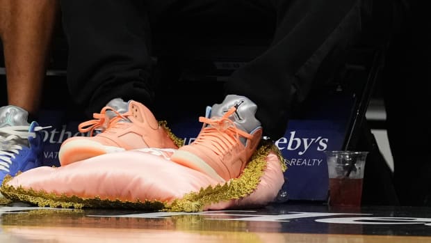 DJ Khaled sits courtside during a game.