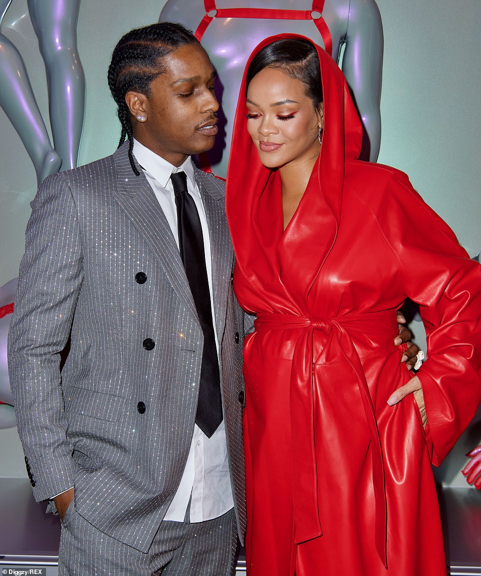 Supportive: A$AP Rocky happily posed before his lady love in front of the wall of lingerie-clad forms in a sparkly grey suit