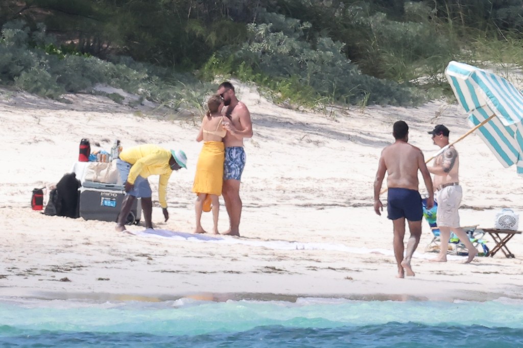 Taylor Swift and Travis Kelce kiss on the beach while on vacation on Harbour Island, Bahamas on Thursday, March 21, 2024. 