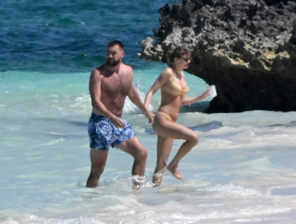 Taylor Swift and Travis Kelce hold hands in the ocean while on vacation on Harbour Island, Bahamas on Thursday, March 21, 2024. 