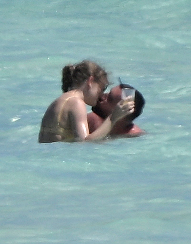 Taylor Swift and Travis Kelce kiss in the ocean while on vacation on Harbour Island, Bahamas on Thursday, March 21, 2024. 