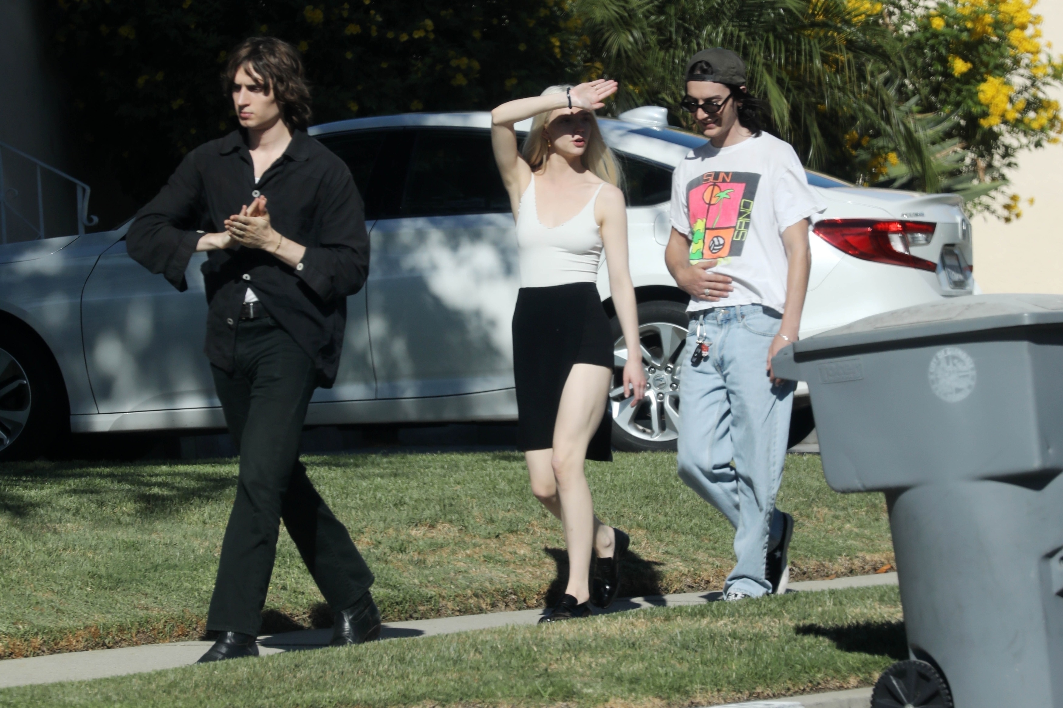 Anya Taylor-Joy and Malcolm McRae walking with a friend.