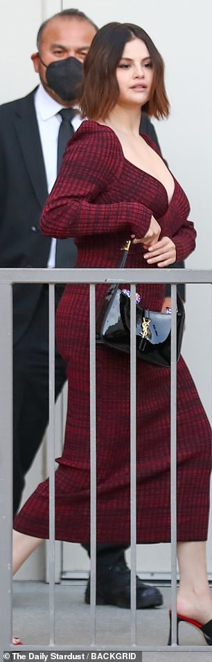 Details: Selena's look for the day included a knit gown in a rich burgundy shade that featured buttons up the leg and criss-cross detail at the bust