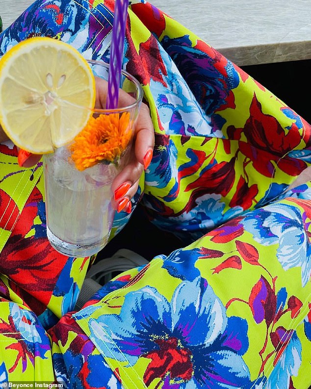 Staying cool: She cooled down with another drink garnished with a lemon slice and a flower