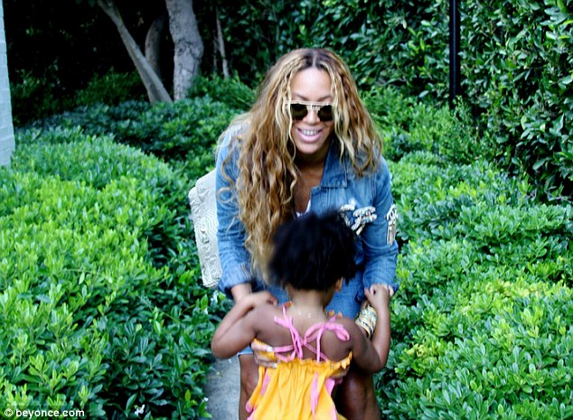 Mama's shy girl: Beyonce's two-year-old daughter Blue Ivy buried her face in her mother's arms in this sweet snap shared on the singer's website