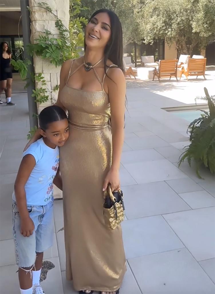 kim kardashian smiling as her daughter chicago clings to her