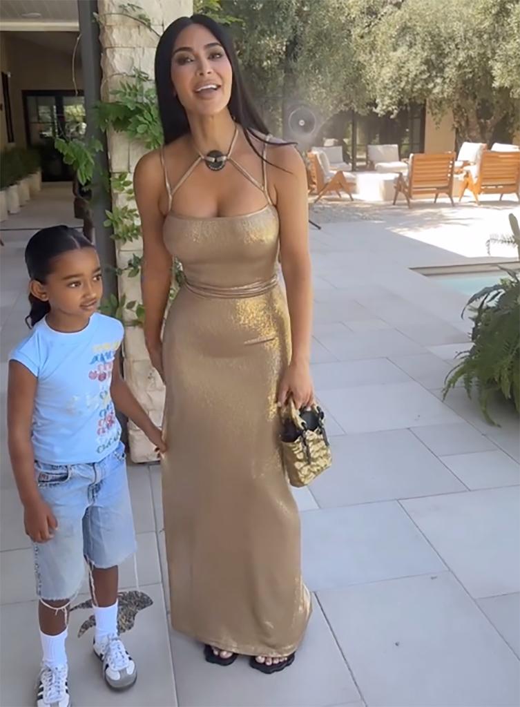 kim kardashian smiling as her daughter chicago clings to her