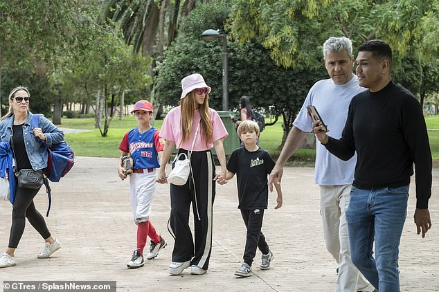 Sweet: She appeared in great spirits as she walked hand-in-hand with her sons Milan, nine, and Sasha, seven, as they head to the stands